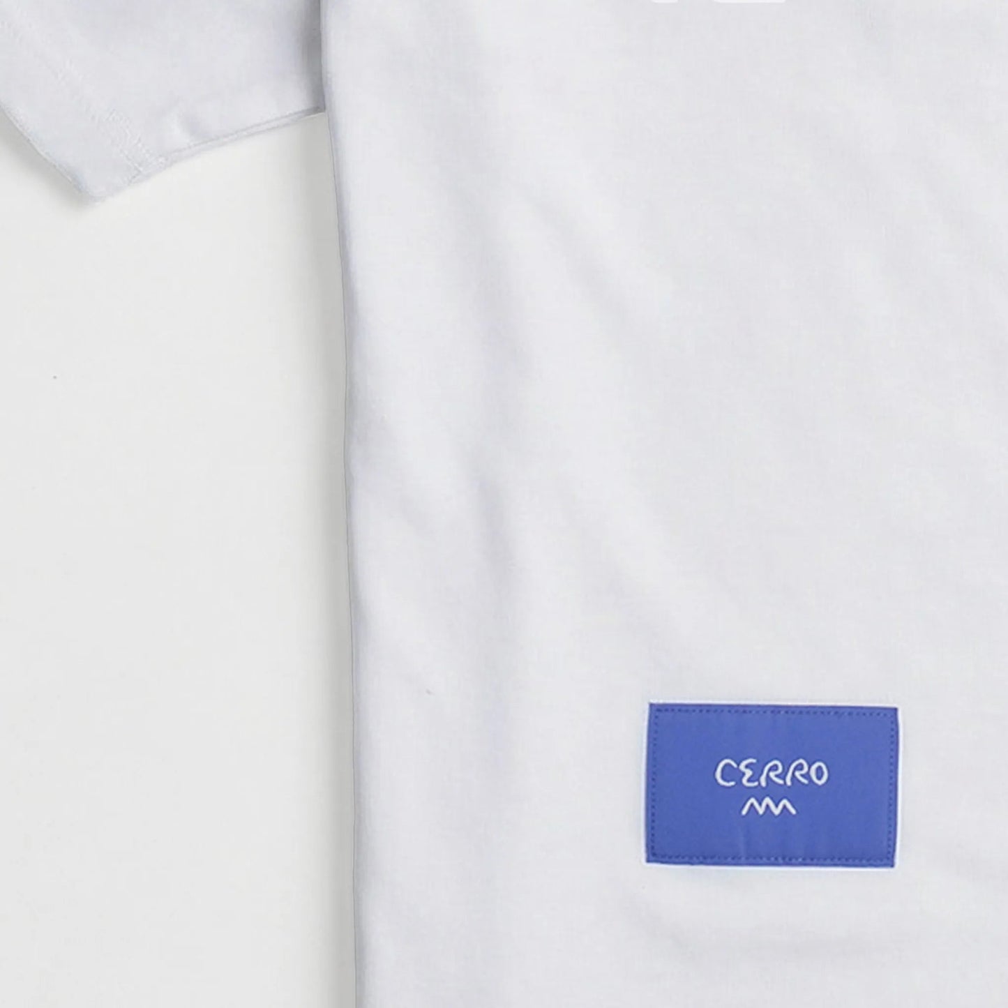 White shirt with a blue patch displaying 'Cerro' on a white background