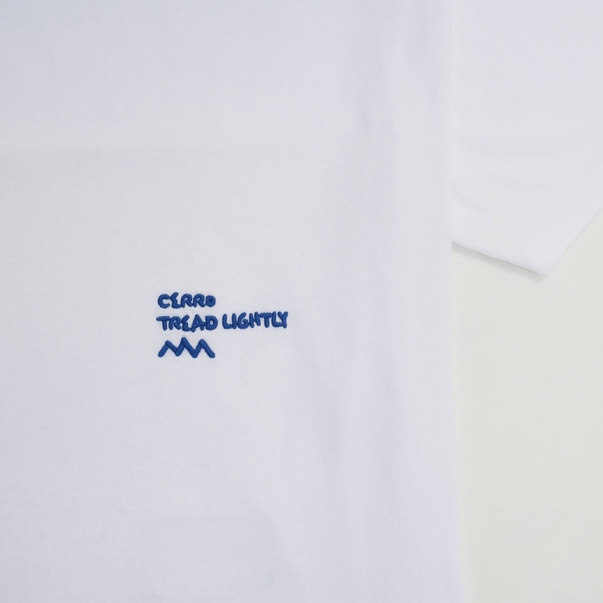 White shirt with embroidered blue text and logo on a white background