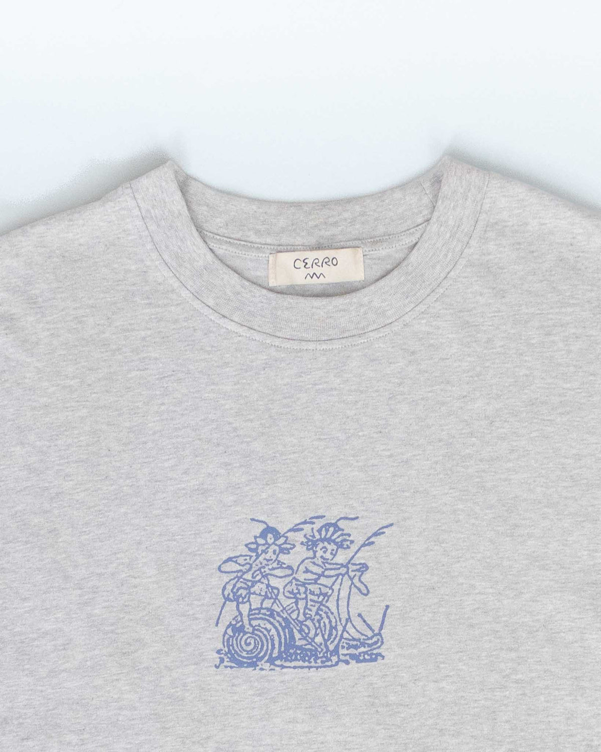 A close-up of a light gray heather crewneck sweatshirt featuring a blue line art graphic of two figures on a snail on the chest. The brand label 'CERRO' is visible inside the collar.